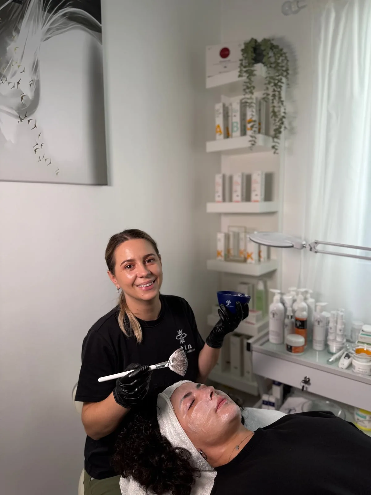 Ștefania aplicând o mască în timpul unui tratament facial